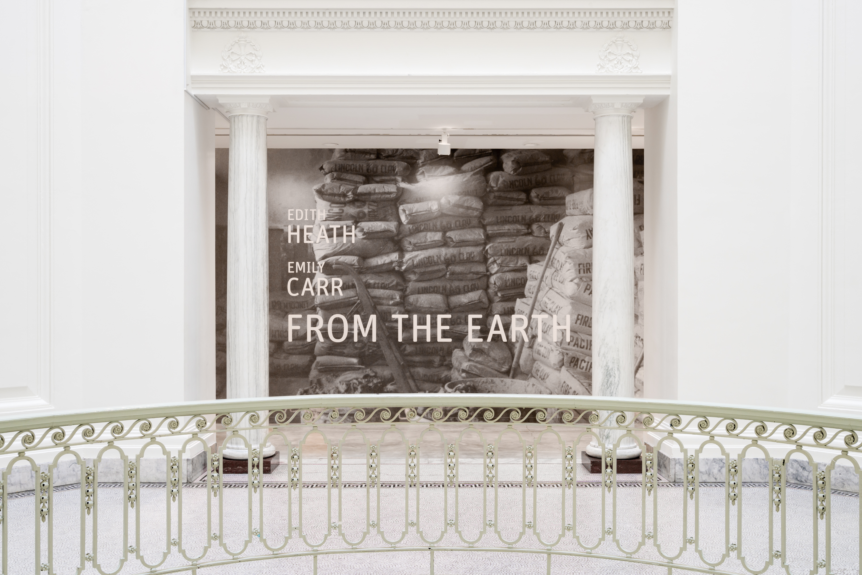 Installation view of the title mural of the exhibition, showing the architecture of the Gallery rotunda, with a rounded white banister.