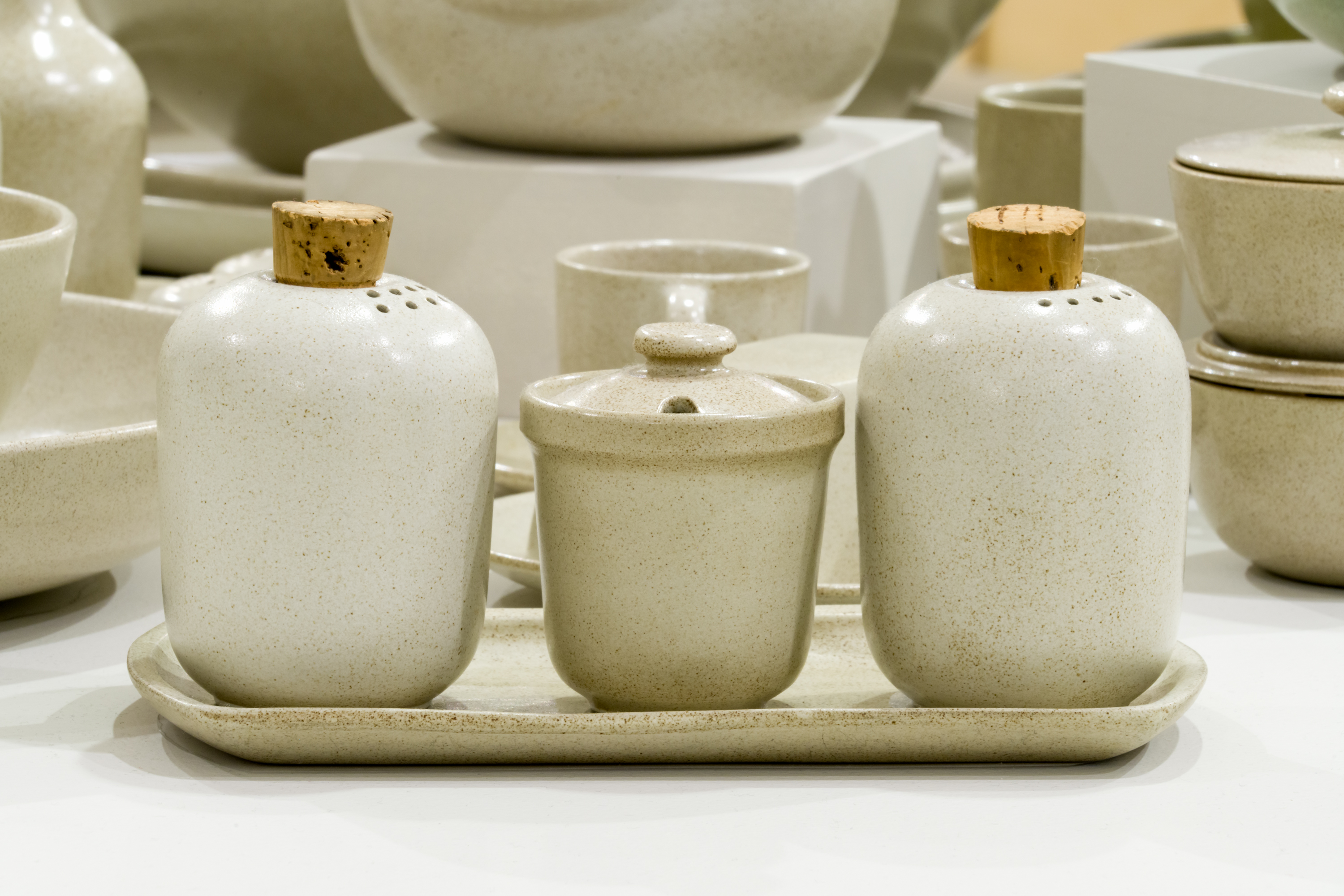 Salt and pepper shakers with a sugar bowl in between, in beige glaze.