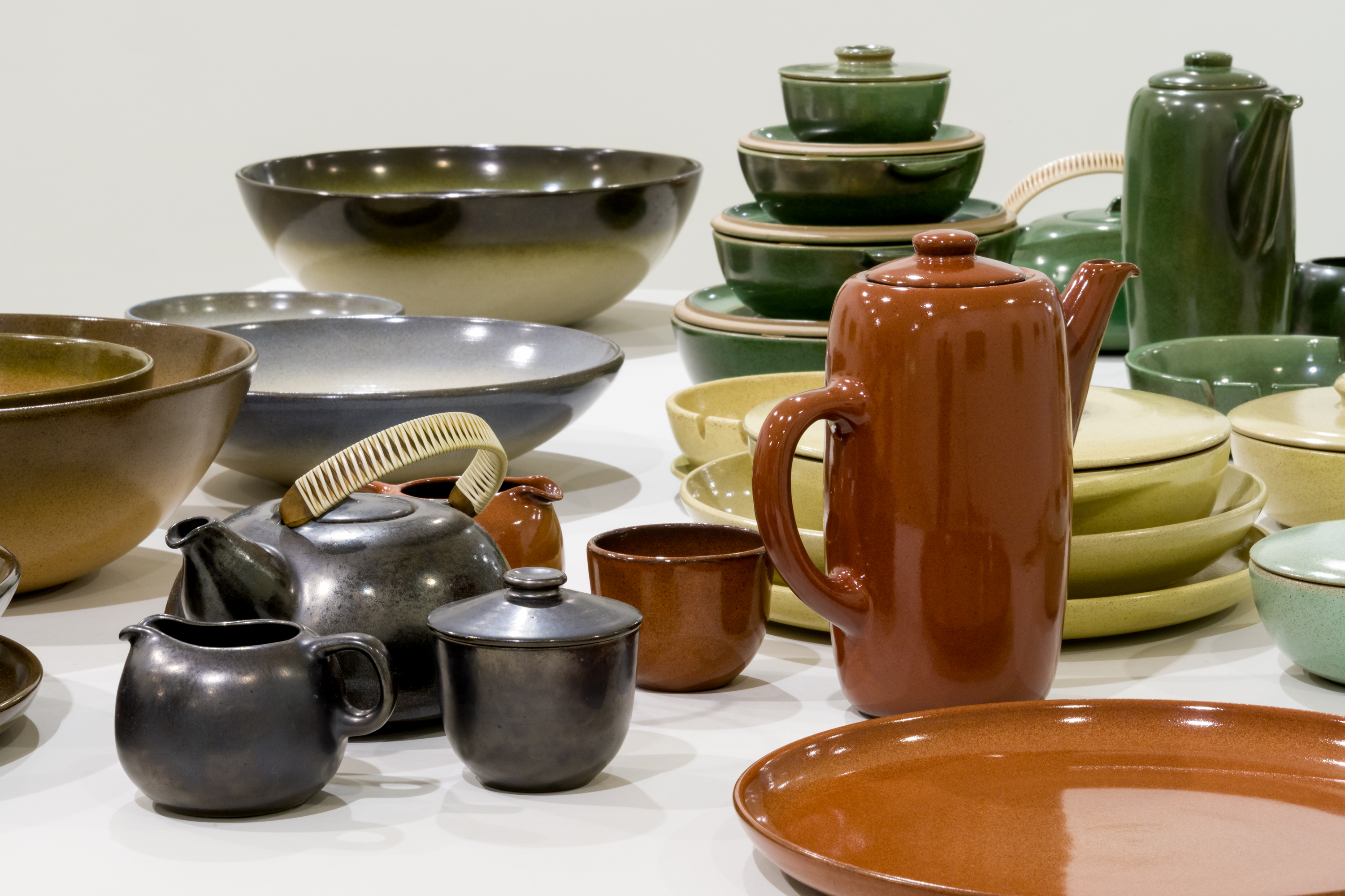 Ceramic jars, plates and a kettle in red, dark purple glazes.