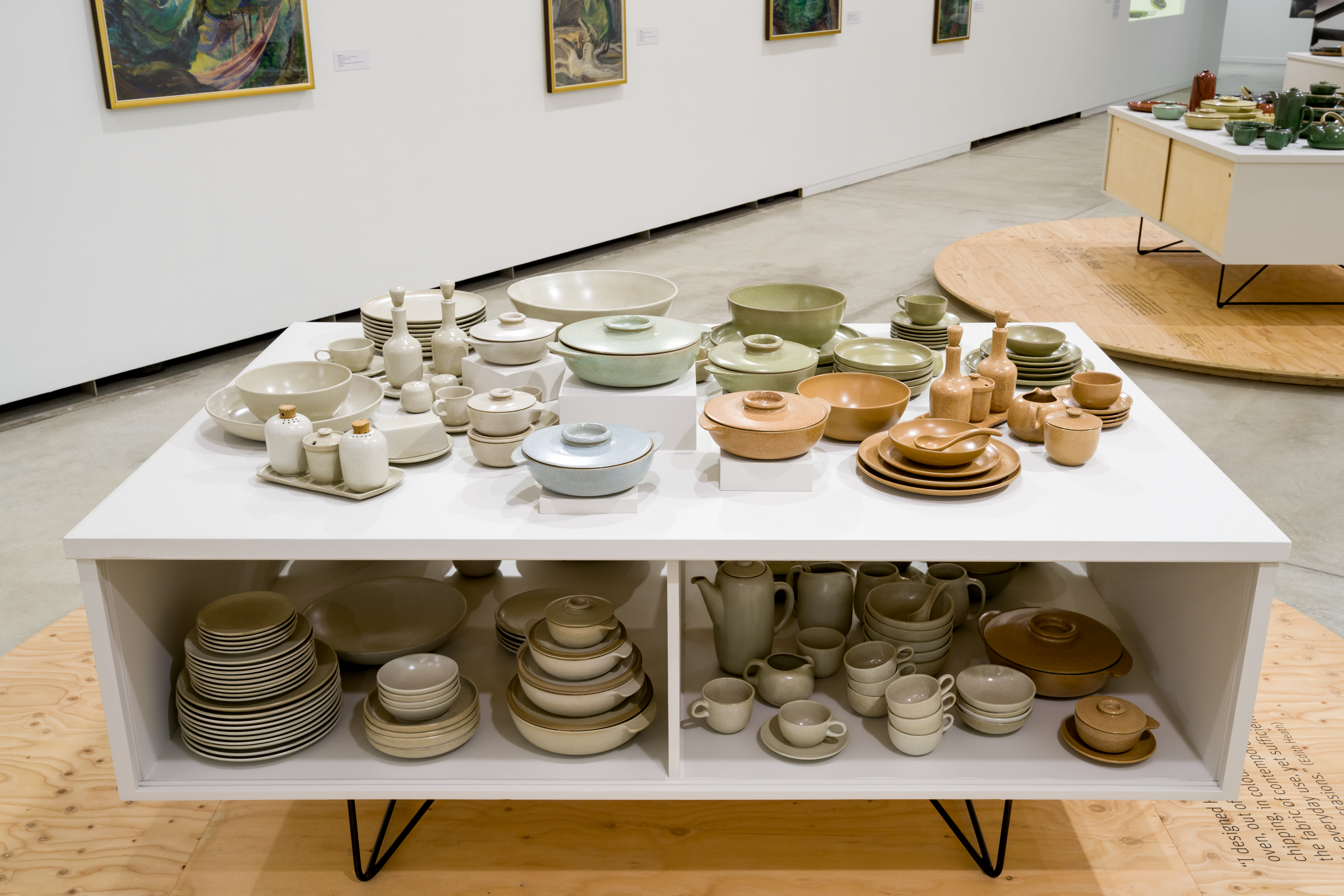 Photograph of an open Conover cabinet holding light coloured ceramic dinnerware.
